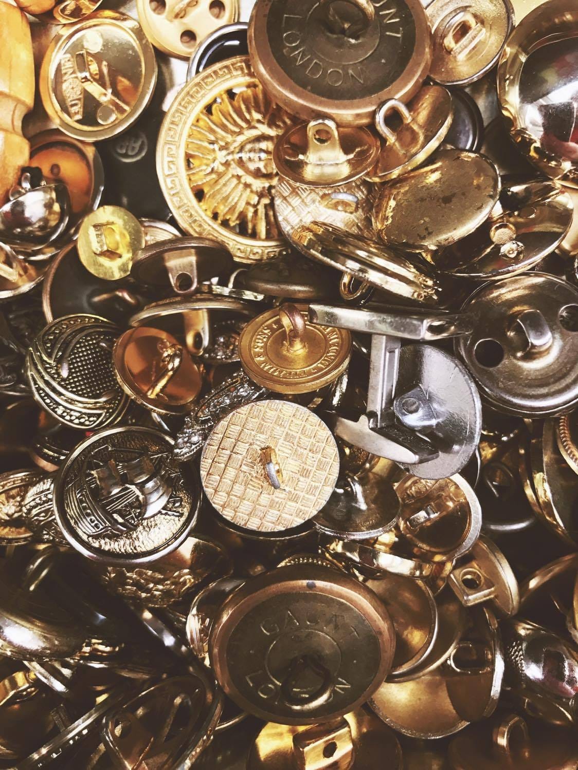 Close-up of a pile of vintage gold and brass buttons